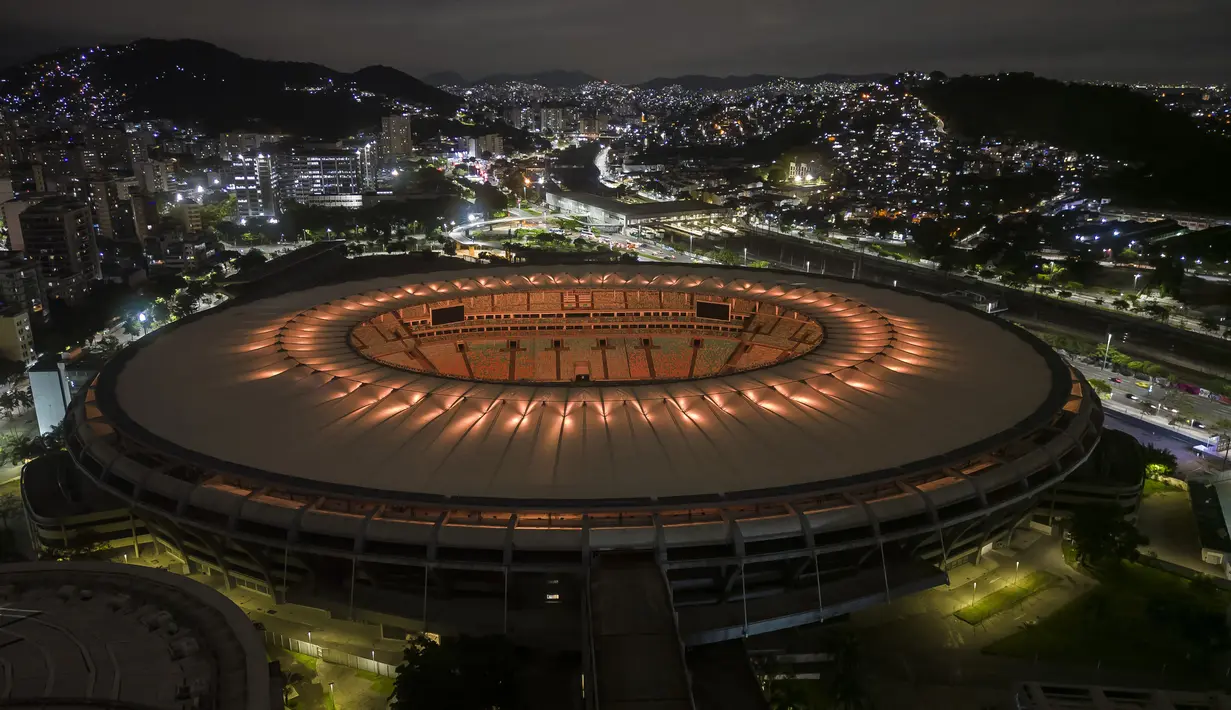 Stadion Maracana diterangi dengan warna kuning, salah satu warna bendera nasional Brasil, untuk menghormati mendiang legenda sepak bola Pele, di Rio de Janeiro, Brasil, Kamis 29 Desember 2022, Edson Arantes do Nascimento atau yang dikenal sebagai Pele telah meninggal dunia di Sao Paulo. Sebelum kepergiannya, Pele menjalani perawatan intensif di rumah sakit Albert Einstein, Sao Paulo selama satu bulan terakhir untuk berjuang sembuh dari kanker usus yang dideritanya sejak 2021. (AP Photo/BrunaPrado)