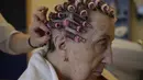 Maribel Elizondo, 90 tahun, menata rambutnya di salon rambut di panti jompo Ibaneta, di desa kecil Erro, sekitar 30 km (18 mil) dari Pamplona, Spanyol utara, Senin, (22/3/2021). Setiap minggu, pada Senin, penata rambut Gloria Cerdan melayani penghuni di panti jompo. (AP Photo/Alvaro Barrientos)