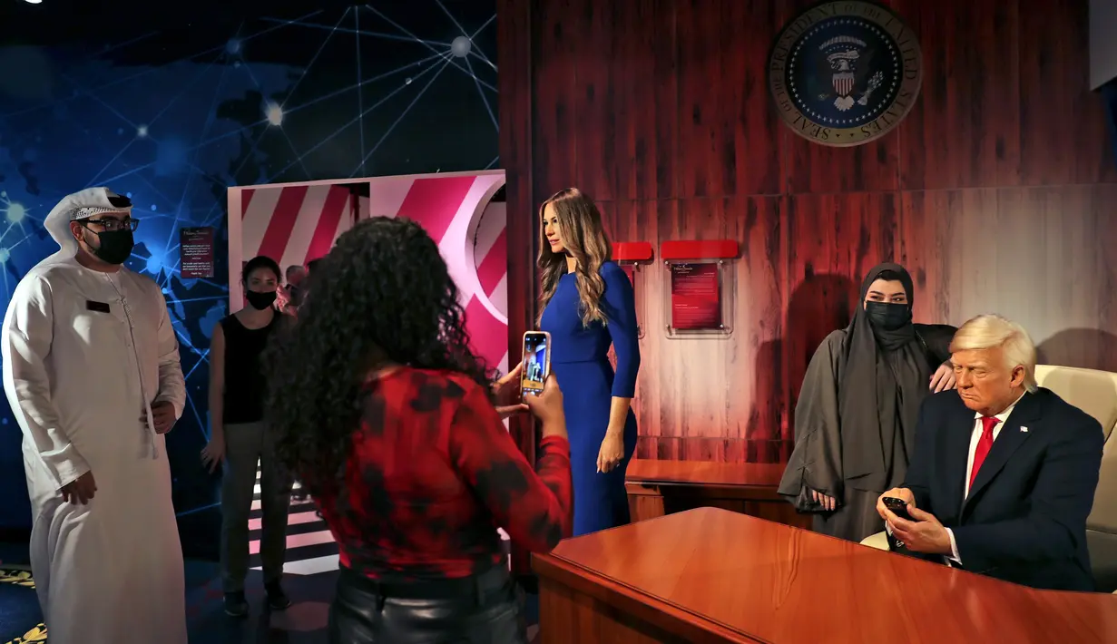 Orang-orang mengunjungi patung lilin mantan Presiden AS Donald Trump dan istrinya Melania pada pembukaan museum Madame Tussauds, di Dubai, Uni Emirat Arab, Rabu (13/10/2021). Atraksi lilin terkenal di dunia ini menampilkan koleksi patung lilin dari lebih 60 tokoh terkenal dunia. (AP/Kamran Jebreili)