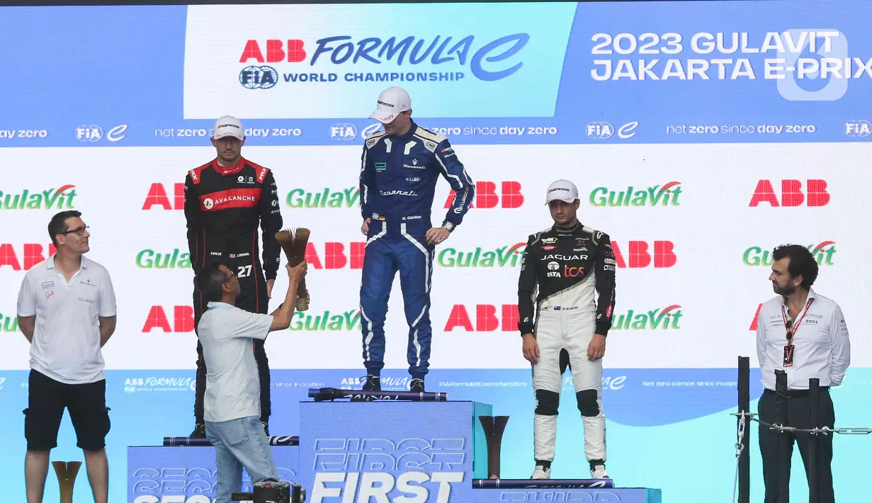 Pj Gubernur DKI Jakarta Heru Budi Hartono menyerahkan trofi kepada pembalap Maserati MSG Racing Maximilian Gunther dari Jerman seusai balapan Formula E 2023 Jakarta seri ke-11 di Jakarta International E-Prix Circuit (JIEC), Jakarta, Minggu (4/6/2023). (Liputan6.com/Herman Zakharia)