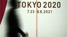 Seorang pria yang mengenakan masker pelindung untuk mencegah penyebaran virus corona berjalan di depan iklan Olimpiade Tokyo 2020 di Tokyo, Rabu (17/3/2021). Ibukota Jepang mengonfirmasi lebih dari 400 kasus virus korona baru pada hari Rabu. (AP Photo/Eugene Hoshiko)