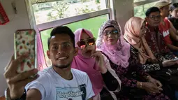 Penyerang timnas Indonesia, Andik Vermansah, menikmati perajalan menggunakan kereta api Prambanan Ekspres dari Solo menuju Yogyakarta pada Rabu (7/9/2016). (Bola.com/Vitalis Yogi Trisna)