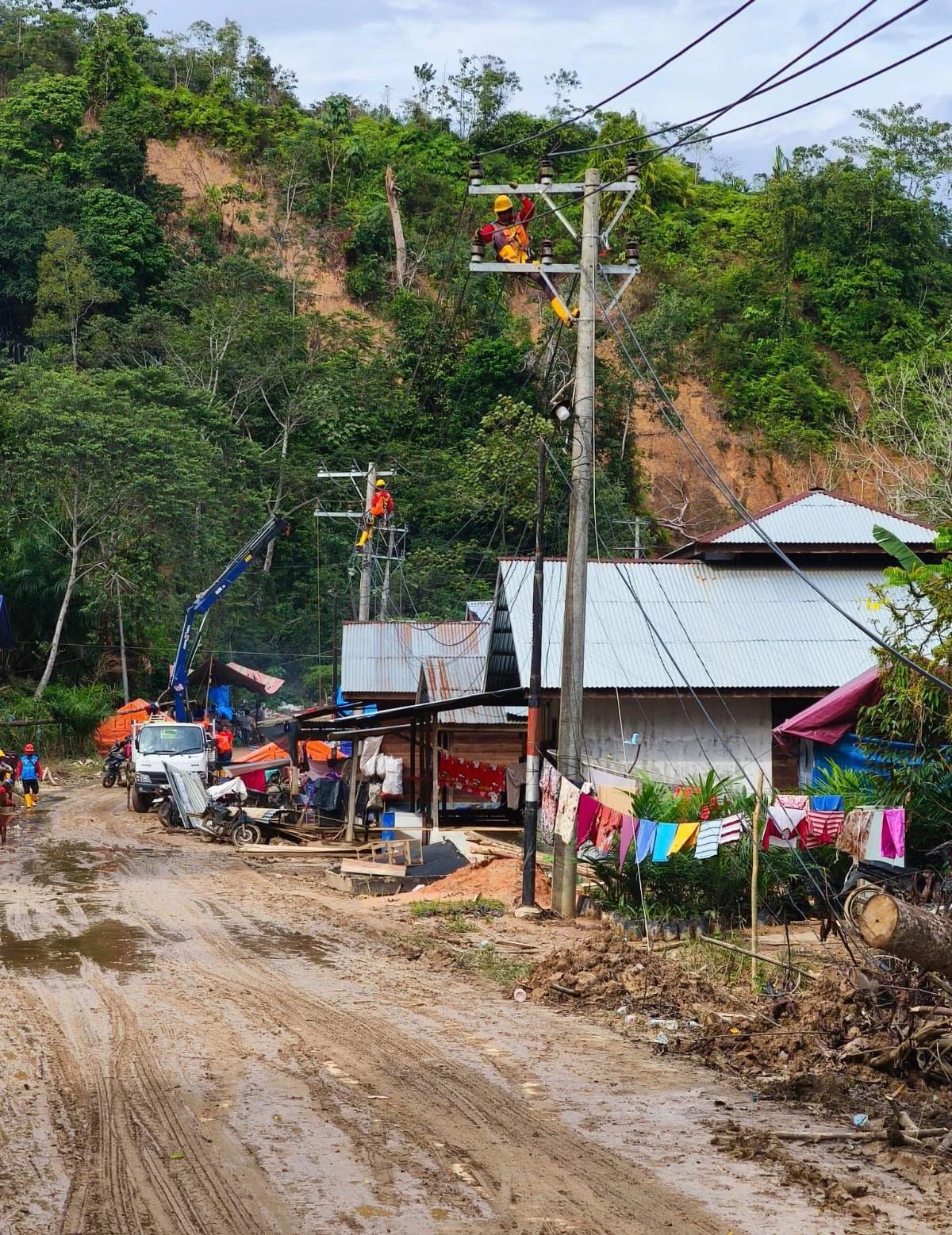 Petugas PLN sedang memperbaiki konstruksi jaringan listrik di Desa Lubuk Sibuk, Kuala Simpang, Aceh Tamiang.
