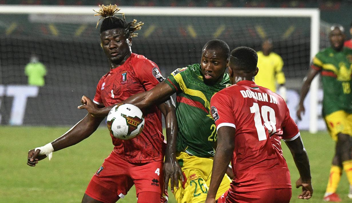 Gelandang Guinea Khatulistiwa Federico Bikoro (kiri) berebut bola dengan gelandang Mali Mohamed Camara (tengah) pada babak 16 besar Piala Afrika 2021 di Stadion Limbe, Kamis (27/1/2022) dini hari WIB. Guinea Ekuatorial mempermalukan Timnas Mali 6-5 (0-0) dalam adu penalti. (Issouf SANOGO/AFP)