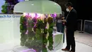 Seorang pria melihat kebun hijau vertikal di pameran Mobile World Congress (MWC) di Barcelona (28/6/2021). MWC 2021 berlangsung mulai 28 Juni sampai 1 Juli secara virtual, dan offline. (AFP/Pau Barrena)