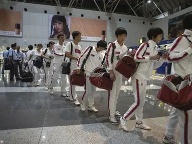 Wanita Korea Utara yang mengenakan baju olahraga dengan bendera Korea Utara dan kata-kata Taekwon-Do tercetak di belakang berjalan ke bea cukai Tiongkok setelah check-in untuk penerbangan ke Astana di Bandara Ibu Kota di Beijing, Jumat, 18 Agustus 2023.