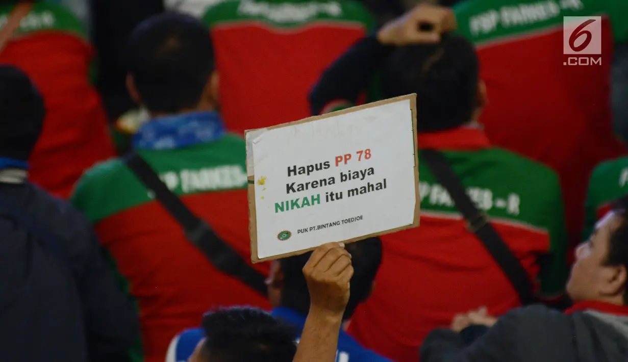 Massa buruh mengangkat poster bertuliskan tuntutan dalam aksi peringatan Hari Buruh 2019 di Tenis Indoor Senayan, Jakarta, Rabu (1/5/2019). Aksi peringatan May Day yang digelar KSPI itu untuk menyuarakan kesejahteraan buruh serta demokrasi jujur dan damai. (merdeka.com/Imam Buhori)