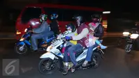 Pemudik motor membawa anak mereka yang masih kecil saat melintasi jalur Pantura, Jawa Barat, Jumat (1/7). Masih banyak pemudik dengan sepeda motor yang nekat membawa anak kecil dan melebihi kapasitas muatan. (Liputan6.com/Angga Yuniar)