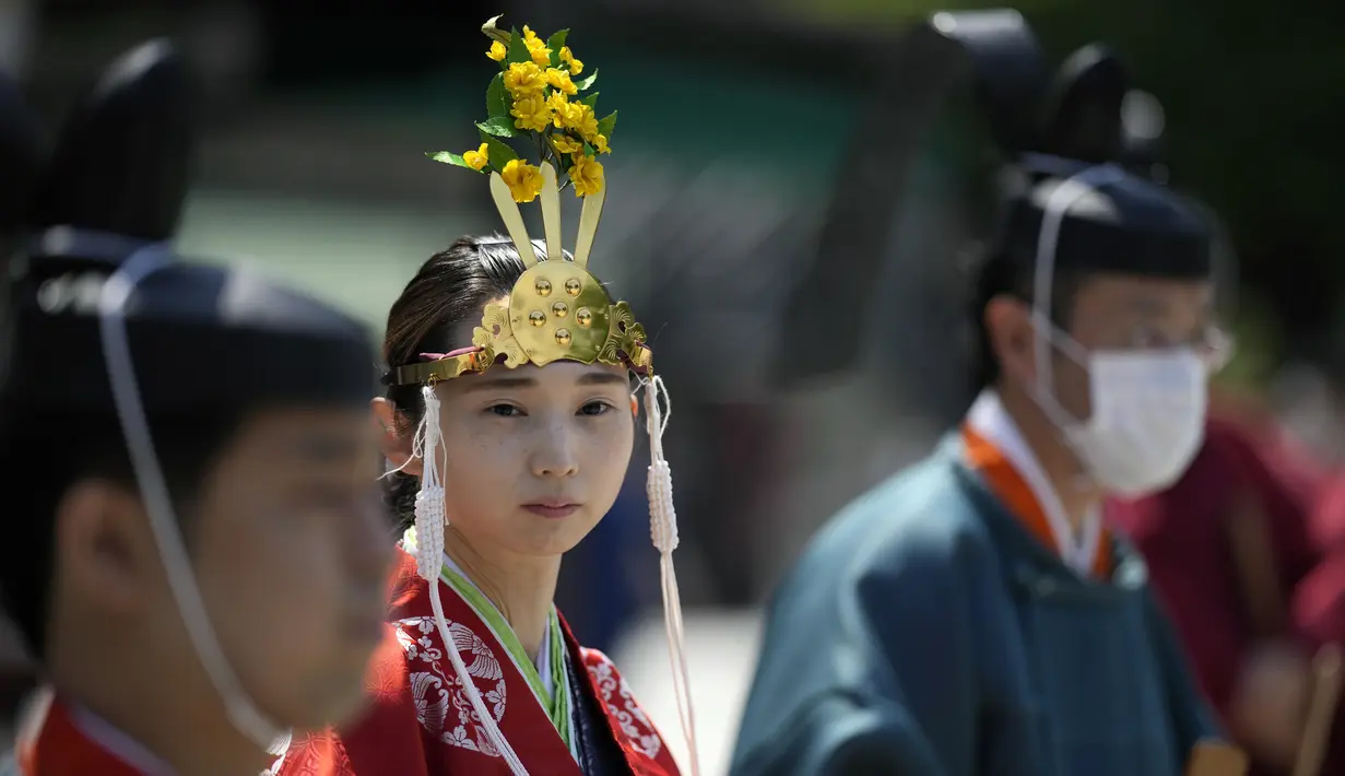 Seorang pendeta muda Shinto yang disebut "miko," tengah, dan pendeta Shinto mempersiapkan upacara upacara untuk festival dua tahunan yang disebut "Kanda Matsuri" di kuil Kanda (18/5/2022). (AP Photo/Eugene Hoshiko)