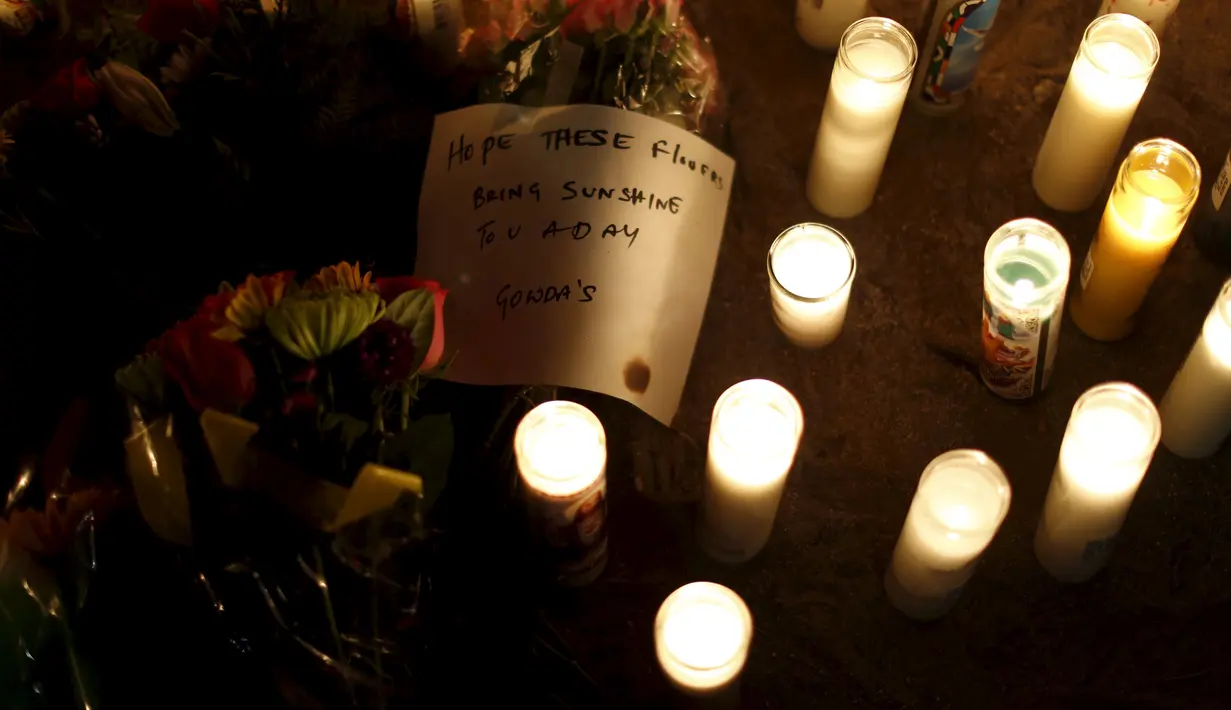 Sebuah pesan tampak diletakkan di antara lilin saat aksi  berdoa bersama di San Bernardino, California, Jumat (4/12). Aksi tersebut untuk korban penembakan brutal di pusat lembaga pelayanan sosial yang menewaskan 14 orang (REUTERS/Mario Anzuoni)