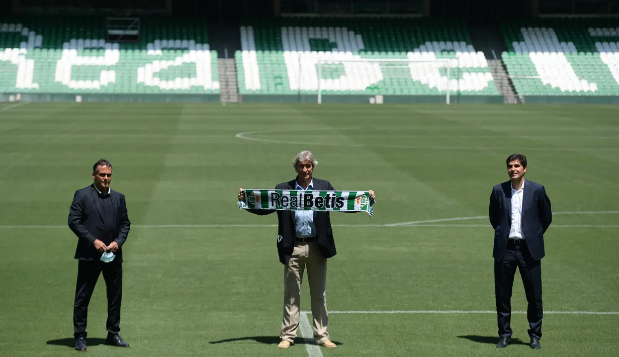 Pelatih Manuel Pellegrini foto bersama dengan presiden Real Betis, Angel Haro dan direktur sepakbola tim, Alexis Trujillo selama presentasinya sebagai pelatih baru di stadion Benito Villamarin di Seville (13/7/2020). (AFP/Cristina Quicler)
