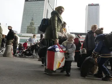 Pengungsi Ukraina menunggu transportasi di stasiun kereta pusat di Warsawa, Polandia, Minggu (27/3/2022). Lebih dari 3,7 juta orang telah melarikan diri dari perang Rusia vs Ukraina sejauh ini, eksodus terbesar di Eropa sejak Perang Dunia II. (AP Photo/Czarek Sokolowski)