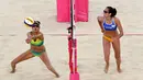 Talika Clancy (kiri) dari Australia berusaha mengembalikan bola saat berhadapan dengan tim Siprus pada pertandingan voli pantai wanita Commonwealth Games 2018 di Gold Coast, Australia (6/4). (AFP Photo/William West)