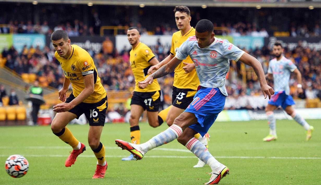 MU juga tak mau kalah. Setelah gol Bruno Fernandes yang dianulir wasit karena offside, Setan Merah ciptakan peluang dari Mason Greenwood (kanan). Pemain 19 tahun tersebut melesatkan bola dengan kaki kirinya yang sedikit melebar dari gawang Wolves. (Foto: AFP/Oli Scarff)