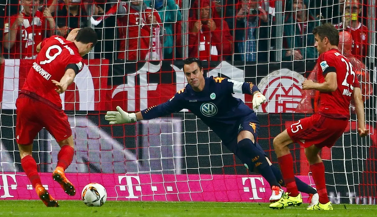 Penyerang Bayern Muenchen, Robert Lewandowski berusaha menendang bola ke arah gawang Diego Benaglio pada bundesliga di Allianz Arena, Rabu (23/9/2015). Muenchen menang telak atas Wolfsburg dengan skor 5-1. (AFP PHOTO/Michaela Rehle)
