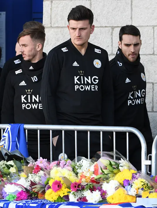 Pemain Leicester City, James Maddison (kiri) bersama Harry Maguire dan Matty James memberi penghormatan atas meninggalnya pemilik Leicester City Vichai Srivaddhanaprabha di luar Stadion King Power, Inggris, Senin (29/10). (Paul Ellis/AFP)