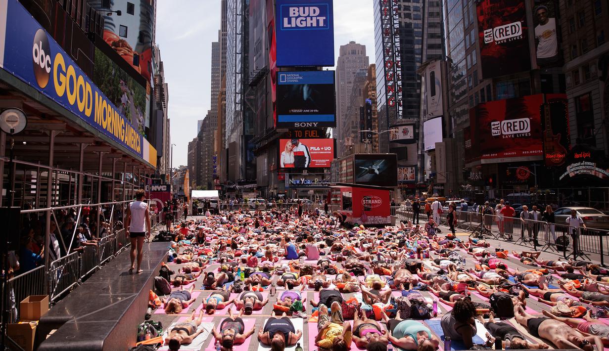 Sejumlah orang mengikuti kelas Yoga yang diadakan oleh Times Square Alliance di Times Square, New York, Amerika Serikat, (20/6). (Drew Angerer / Getty Images / AFP)