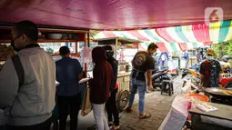 Pedagang melayani pembeli di Pasar Takjil Benhil, Jakarta, Selasa (13/4/2021). Pasar takjil yang ada setiap bulan Ramadhan tersebut dipadati warga untuk membeli makanan berbuka puasa. (Liputan6.com/Faizal Fanani)