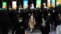 Orang-orang yang memakai masker berjalan di stasiun Shinagawa di Tokyo (18/1/2022). Jepang melaporkan rekor tertinggi infeksi Covid-19 baru yang dipicu oleh varian Omicron. (AFP/Philip Fong)