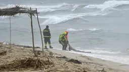 Tim penyelamat menemukan mayat di pantai dekat Cutro, Italia selatan, setelah sebuah perahu migran pecah di laut yang ganas pada Minggu, 26 Februari 2023. Kapal mengangkut imigran itu tenggelam terkena badai di laut lepas pantai wilayah Calabria selatan Italia. (Antonino Durso/LaPresse via AP)