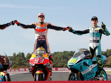 Pembalap MotoGP Marc Marquez (tengah) bersama pembalap Moto2 Alex Marquez (kiri) dan pembalap Moto3 Lorenzo Dalla Porta (kanan) berpose di depan Valencia Motorcycle Grand Prix, Spanyol, Minggu (17/11/2019). Ketiganya sukses merebut gelar juara dunia tahun 2019. (AP Photo/Alberto Saiz)