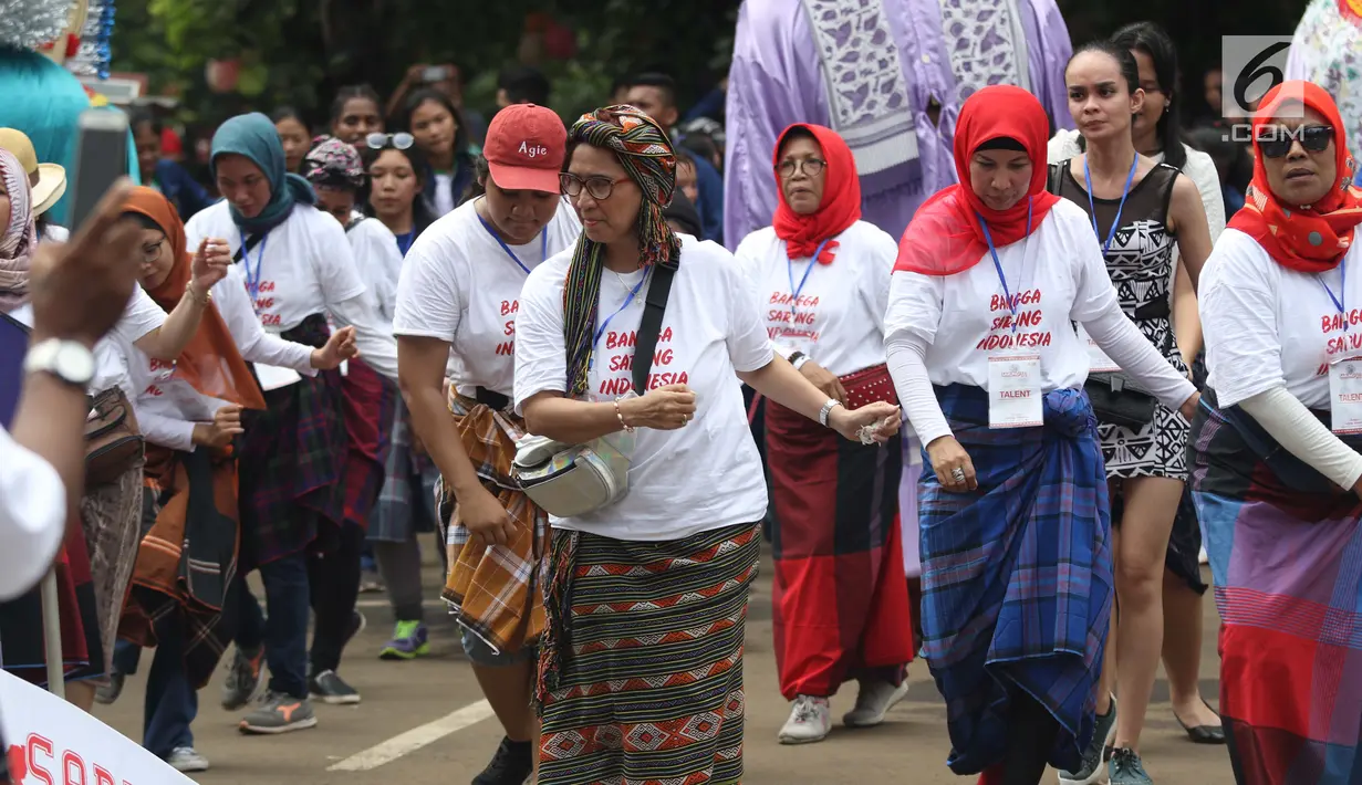 Pengunjung menari saat Festival Sarung Indonesia 2019 di Kawasan Kompleks Gelora Bung Karno, Jakarta, Minggu (3/3). Festival ini untuk menghidupkan kesadaran dan kebanggaan generasi muda akan kekayaan budaya Indonesia. (Liputan6.com/Helmi Fithriansyah)
