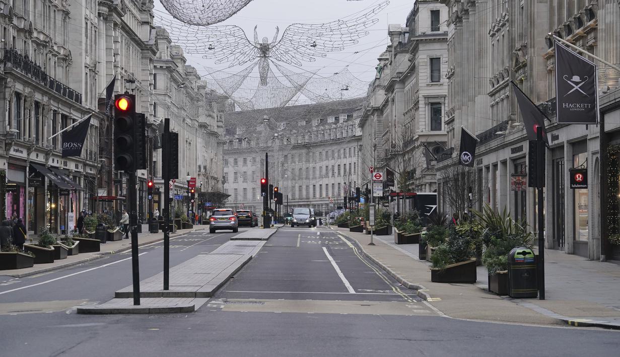 Suasana jalan ke arah Piccadilly Circus, di pusat kota London yang kosong pada Hari Natal, Sabtu (25/12/2021). Dari Bethlehem dan Frankfurt ke London dan Boston, gelombang virus corona varian omicron meredam Malam Natal untuk tahun kedua. (Jonathan Brady/PA via AP)