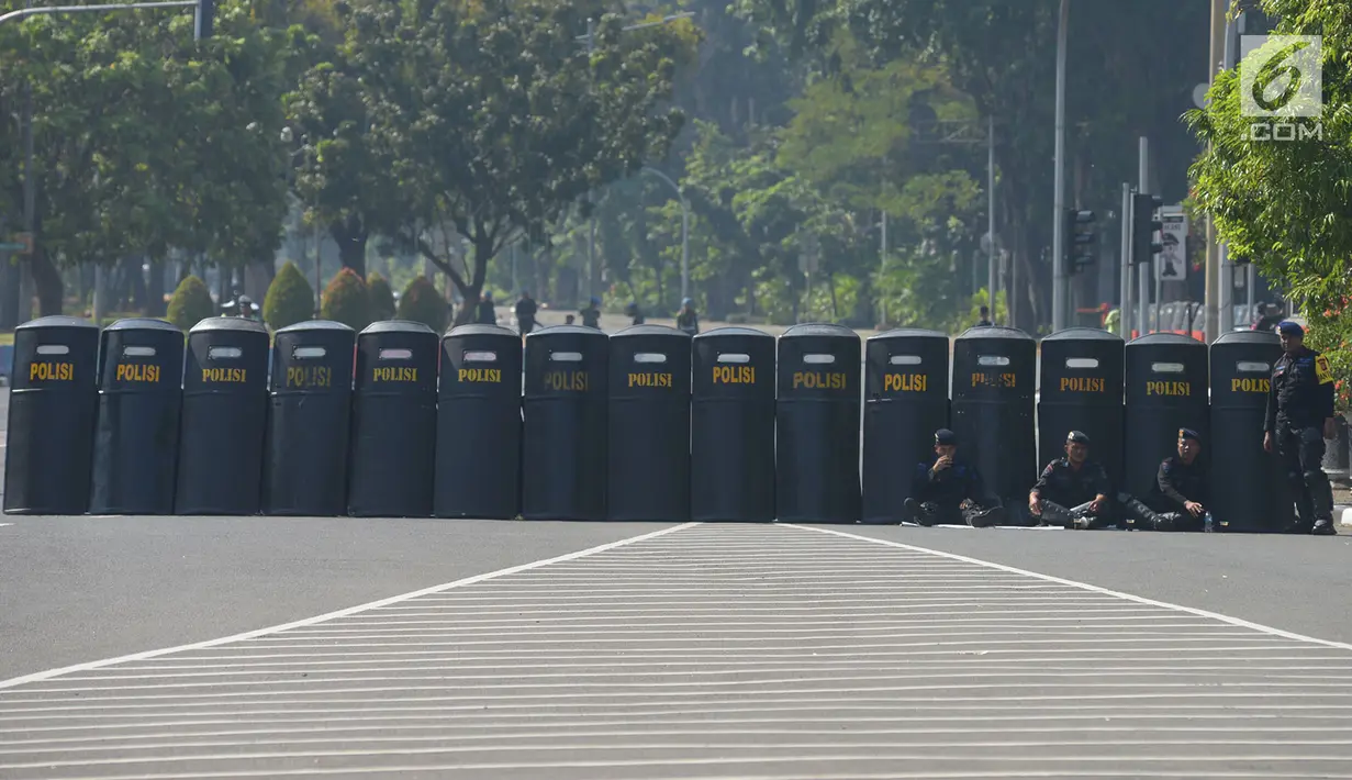 Polisi menyiapkan tameng untuk menutup jalan menuju Gedung Mahkamah Konstitusi (MK), Jakarta, Kamis (27/6/2019). Puluhan ribu personel TNI-Polri dikerahkan guna mengamankan sidang pembacaan putusan hasil sengketa pilpres 2019 serta melakukan penutupan jalan menuju Gedung MK (merdeka.com/Imam Buhori)