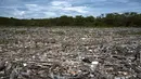 Berton-ton sampah termasuk limbah rumah sakit, botol dan wadah plastik, kayu, dan bahan lain yang dikumpulkan oleh sungai Guaire dan Tuy dalam perjalanannya melalui negara bagian Miranda dan Aragua di Venezuela, mencapai pantai melalui muara di pantai Paparo. (Yuri CORTEZ / AFP)