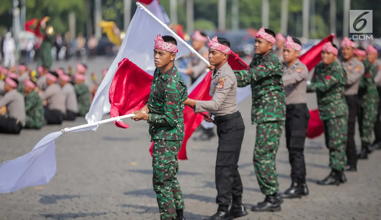 Prajurit TNI dan Polri berkolaborasi memainkan rampak gendang dalam HUT ke-73 Bhayangkara di Monas, Jakarta, Rabu (10/7/2019). HUT Bhayangkara ke-73 ini bertemakan ‘Dengan semangat Promoter, pengabdian Polri, untuk masyarakat, bangsa, dan negara. (Liputan6.com/Faizal Fanani)