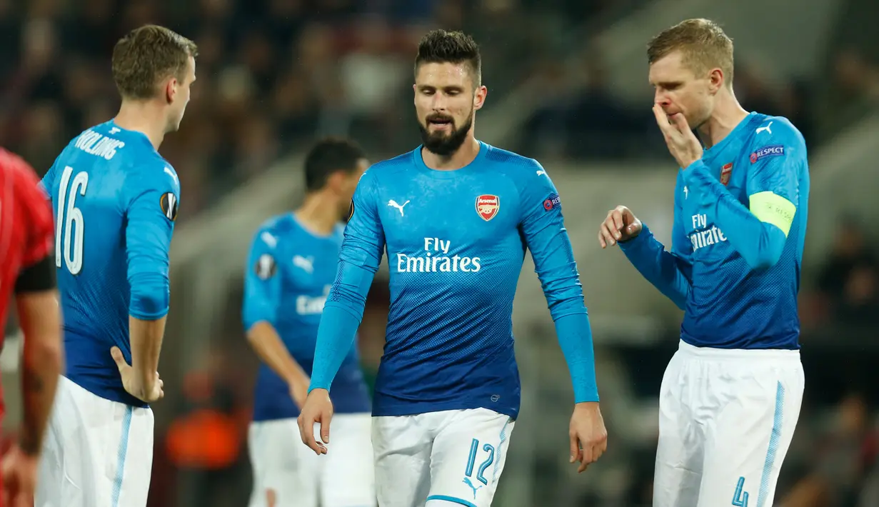 Reaksi pemain Arsenal, Rob Holding, Olivier Giroud dan Per Mertesacker pada matchday 5 Liga Europa Grup H kontra FC Koln di RheinEnergieStadion, Jumat (24/11). Meski kalah 0-1 dari FC Koln, Arsenal tetap lolos sebagai juara Grup H. (INA FASSBENDER/AFP)