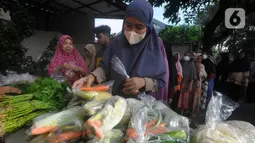 Pembagian sayuran termasuk lauk pauk mentah seperti telur dan ikan kepada kaum ibu. (merdeka.com/Arie Basuki)