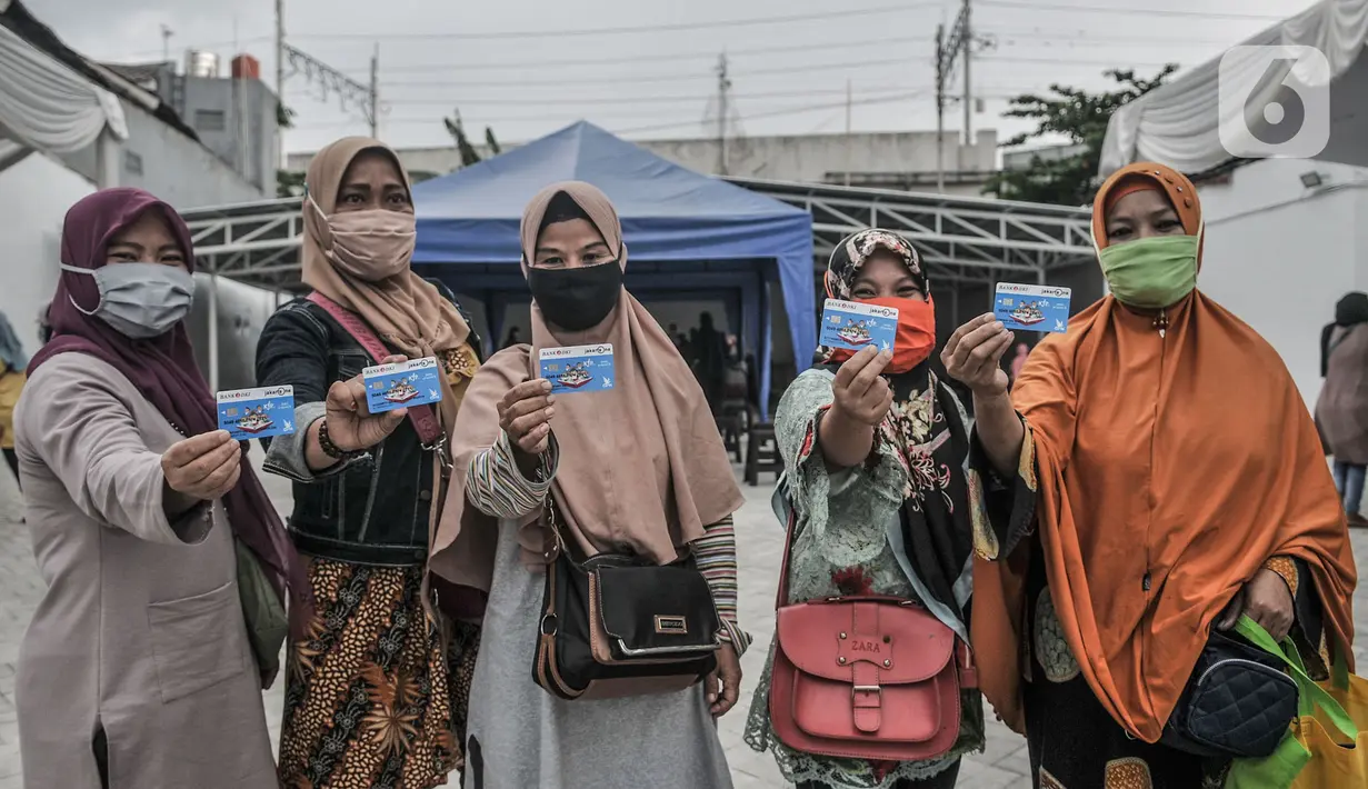 Orangtua dari anak penerima saat menunjukkan KJP yang baru diterima di kawasan Matraman, Jakarta, Selasa (24/11/2020). Penyaluran KJP plus tahap kedua ini menggunakan data baru berdasarkan pembaruan berkas warga penerima yang rampung pada bulan Oktober lalu. (merdeka.com/Iqbal S. Nugroho)