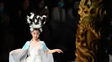 Seorang model cilik menampilkan kreasi dari koleksi Jinshangyuyi karya desainer Wang Cong selama China Fashion Week di Beijing pada Kamis (9/9/2021). Gelaran pekan mode tersebut tetap digelar di tengah pandemi corona covid-19. (Giok GAO / AFP)