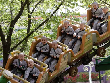 Para biksu cilik menaiki roller coaster saat mengunjungi taman hiburan Everland di Yongin, Korea Selatan, Kamis (2/5). Kunjungan ini merupakan bagian dari program pelatihan mereka saat belajar agama Buddha. (AP Photo/Lee Jin-man)