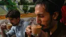 <p>Pria Pakistan meminum secangkir teh di sebuah restoran di Islamabad, Rabu (15/6/2022). Pakistan diketahui merupakan salah satu negara importir teh terbesar dunia yang kini tengah bergulat dengan inflasi yang melonjak dan rupee yang terdepresiasi dengan cepat. (Aamir QURESHI / AFP)</p>