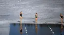 Para perenang bersiap bertanding dalam kompetisi renang musim dingin di lubang es sepanjang 25 meter di danau dekat Vilnius, Lithuania, Sabtu (6/3/2021).  Suhu air saat itu 3 derajat Celcius, sedangkan udaranya -3 derajat Celsius. (AP Photo/Mindaugas Kulbis)