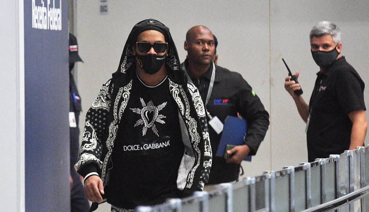 Mantan pemain timnas Brasil, Ronaldinho tiba di bandara El Galeao di Rio de Janeiro, setelah menjalani tahanan rumah di Paraguay, Selasa (25/8/2020). (AFP/Carl dE Souza)