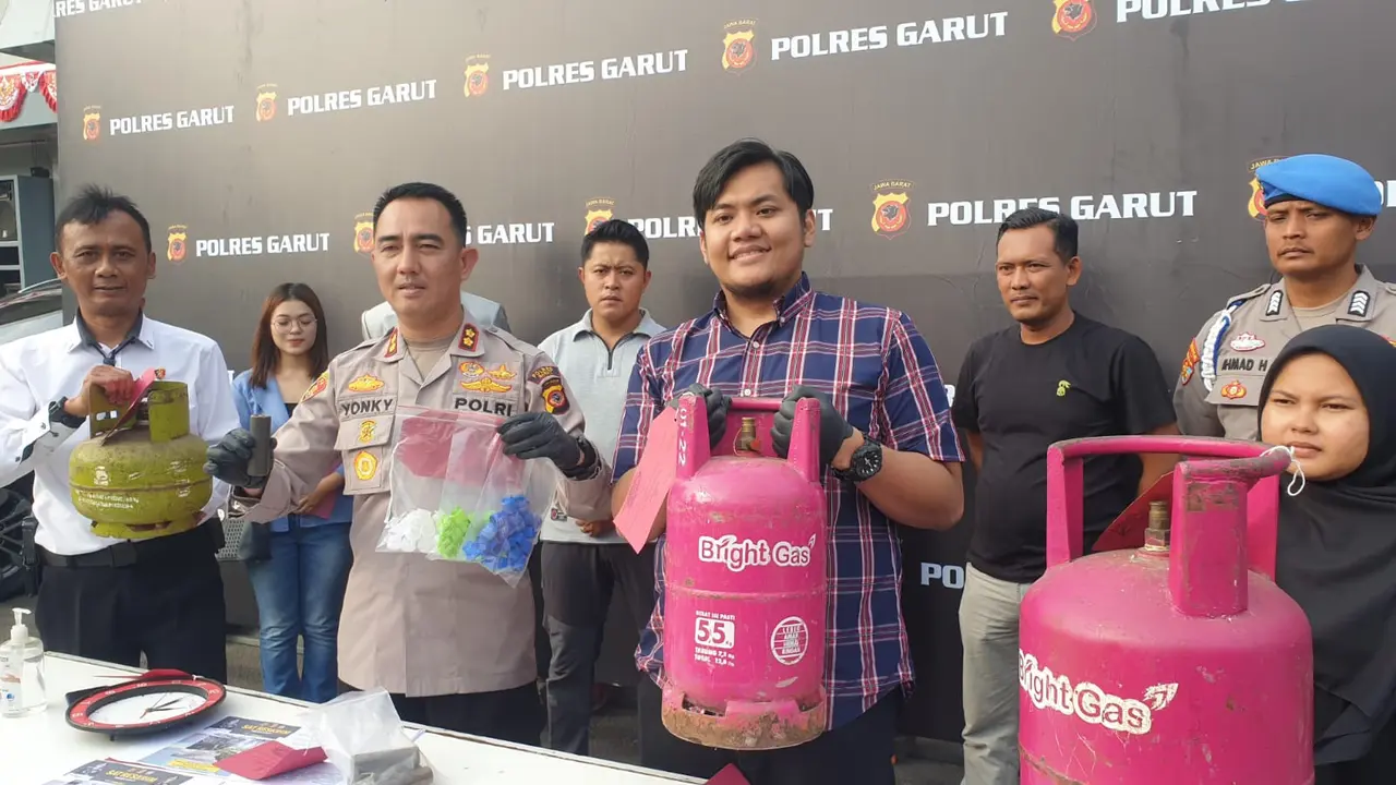 Kapolres Garut AKBP Rohman Yonky Dilatha, menunjukan barang bukti gas oplosan non subsidi dalam rilis kasus di Mapolres Garut, Rabu (23/8/2023) petang. (Liputan6.com/Jayadi Supriadin)