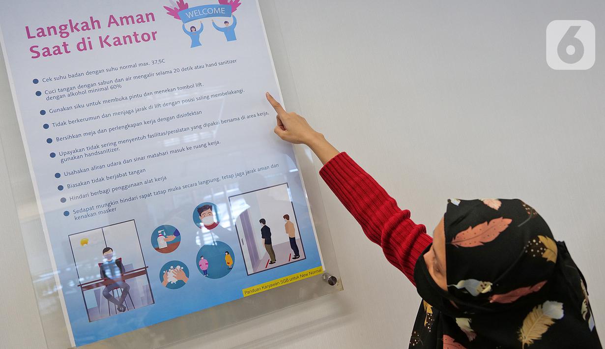 Karyawan melihat panduan langkah aman saat di kantor terkait pencegahan Covid-19 di Suntory Garuda, Jakarta, Senin (8/8/2020). Suntory Garuda menerapkan protokol kesehatan, salah satunya kapasitas karyawan hanya dibolehkan sebanyak 50 persen. (Liputan6.com/Herman Zakharia)