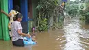 Warga beraktivitas di tengah banjir yang melanda kawasan Cipinang Melayu, Jakarta Timur, Jumat (19/2/2021). Banjir di kawasan tersebut akibat curah hujan yang tinggi dan meluapnya air dari Kali Sunter. (Liputan6.com/Herman Zakharia)