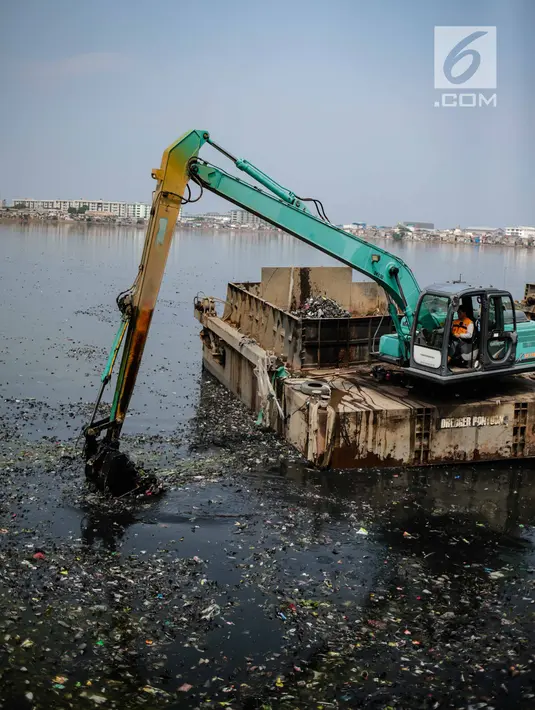 Kendaraan eskavator dan tongkang Dinas Tata Air DKI Jakarta mengeruk lumpur dan sampah dari Waduk Pluit, Jakarta, Selasa (11/12). Pengerukan ini dilakukan untuk menambah kedalaman waduk. (Liputan6.com/Faizal Fanani)