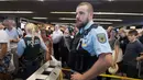 Petugas kepolisian menutup boarding gate untuk masuk pesawat di terminal 1 Bandara Frankfurt, Jerman, Selasa (7/8). Sejumlah penerbangan harus dibatalkan setelah seorang yang tidak dikenal menyusup melewati pos pemeriksaan. (Boris Roessler/dpa via AP)
