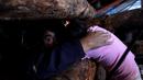 Seorang penambang memeluk kerabatanya saat aksi protes menuntut pemerintah untuk menyediakan dana untuk membuka kembali tambang batubara Santa Ana, di kota Curanilahue, Chile, (26/12). (Reuters/Juan Gonzalez Galaz)