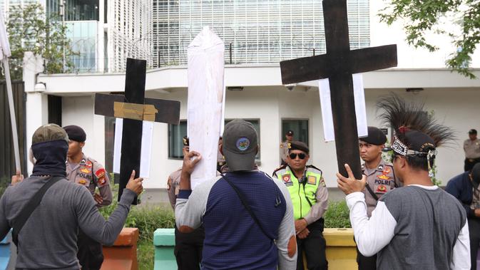 Massa membawa atribut salib dalam unjuk rasa di depan Kedubes AS, Jakarta, Kamis (27/12). Mereka menuntut Dubes AS Joseph R. Donovan Jr bertanggungjawab atas dugaan pelanggaran HAM yang dilakukan oleh PT Freeport Indonesia. (Liputan6.com/Angga Yuniar)