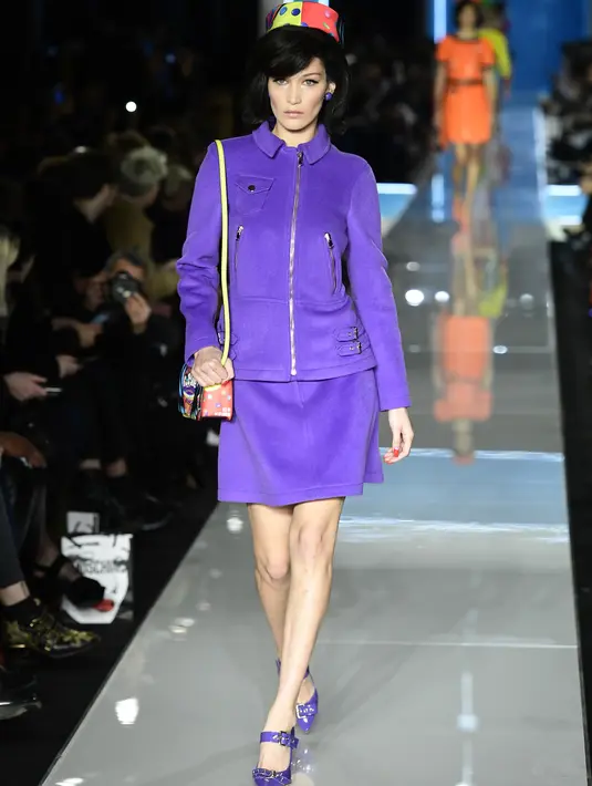 Model AS, Bella Hadid berjalan membawakan koleksi terbaru Moschino di panggung runway Milan Fashion Week 2018, Rabu (21/2). Bella Hadid terlihat menggunakan skirt suit berwarna ungu muda dengan pillbox hat colorful pattern yang manis. (Miguel MEDINA/AFP)