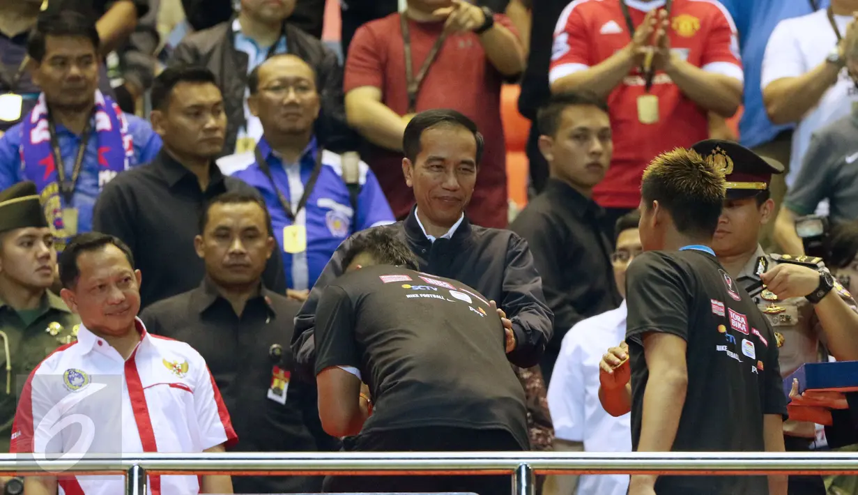 Presiden Joko Widodo mengalungkan medali ke pemain Arema FC, Johan Ahmat Farizi usai final di Stadion Pakansari, Kab Bogor, Minggu (12/3). Arema menang 5-1 atas PBFC dan berhasil merengkuh trofi Piala Presiden. (Liputan6.com/Helmi Fithriansyah) 