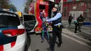 Pendaki pencakar langit, Alain Robert, yang juga dikenal sebagai 'Spiderman Prancis' melambaikan tangan saat ditahan kepolisian usai memanjat Menara Agbar setinggi 144 meter di Barcelona, Rabu (4/3/2020). Alain Robert telah menaklukkan lebih dari 100 bangunan di seluruh dunia. (AP/Joan Mateu)