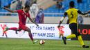 <p>Gelandang Timnas Indonesia U-23, Saddil Ramdani mencoba melepaskan tembakan dari kawalan bek Malaysia, Harith Haiqal bin Adam Afkar dalam pertandingan perebutan medali perunggu SEA Games 2021 di Stadion My Dinh, Minggu (22/5/2022). Indonesia ditahan imbang 1-1 dan menang 4-3 di adu penalti. (AFP/Ye Aung Thu)</p>