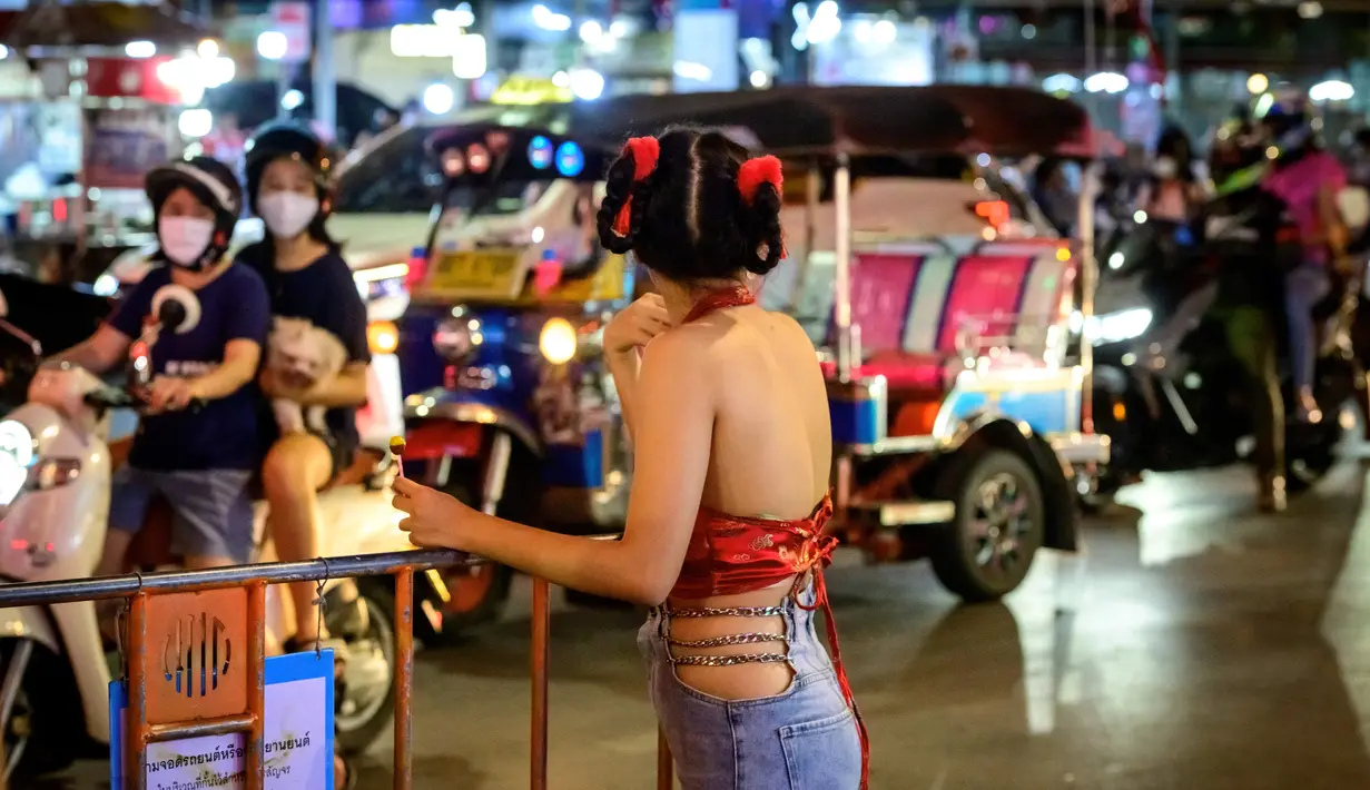Seorang wanita berpose di jalan utama Chinatown Bangkok, didekorasi untuk menyambut Tahun Baru Imlek (9/2/2021). Perayaan Tahun Baru Imlek 2021 di Chinatown Yaowarat Bangkok secara resmi dibatalkan menurut Administrator Metropolitan Bangkok. (AFP/ Mladen Antonov)